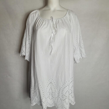 blouse blanche femme grande taille chic et original . Ce haut long de style bohème en coton blanc se distingue par sa broderie anglaise. Il se marie parfaitement avec des sandales et des accessoires, et sa coupe évasée est idéale pour la saison estivale. vetements grandes tailles chic​